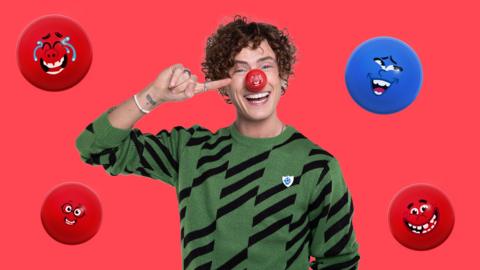 Joel from Blue Peter is wearing a red nose and pointing at it smiling. He is surrounded by cartoon images of other red noses.