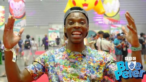 CBBC's Rhys wearing a Pokemon tshirt and looking very excited.