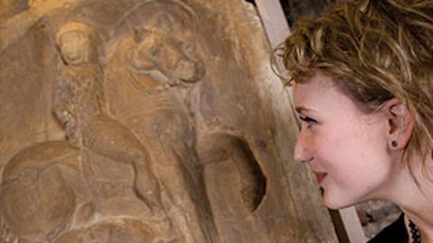 A woman looking at Roman pottery.
