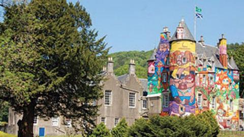 The outside of the castle with a large painted wall