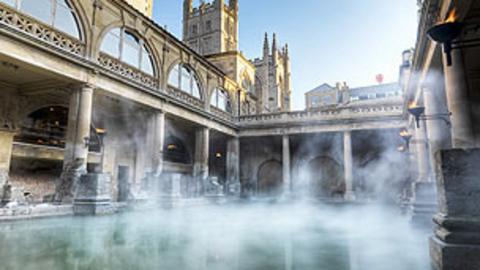 The roman baths with steam rising from the water.
