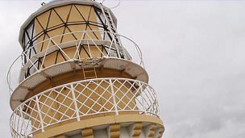 The top part of a beige lighthouse.