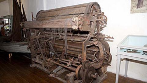 An old piece of nautical machinery, with netting over it.