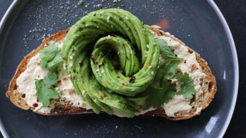 Avocado in a the shape of a rose on toast.