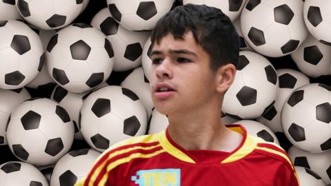 Jamie Johnson in front of multiple footballs.