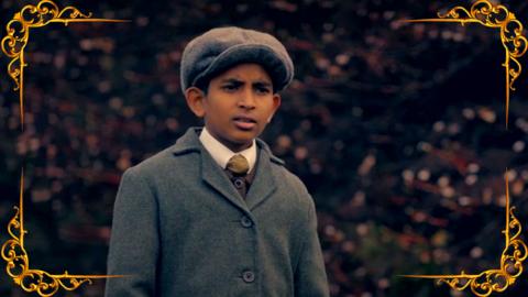 A Victorian boy looks on at something off camera in the distance. From CBBC series Hetty Feather.