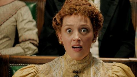 A lady looking surprised at the cinema.