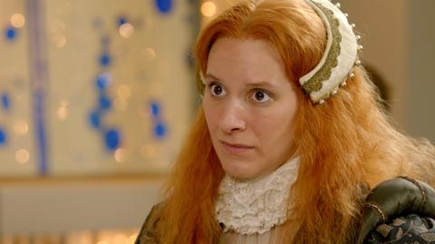 Cast member dressed as Elizabeth I looks disgruntled in the Historical First Dates restaurant.