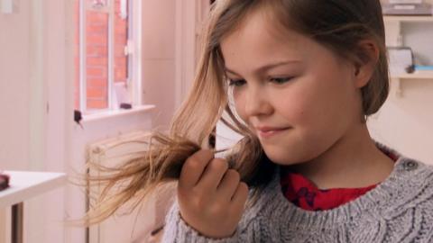 A girl looking at her own hair.