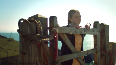 Gwendoline leaning on a gate on the cliff path.
