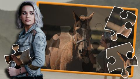 A young girl, Issie, is holding a giant jigsaw piece. Behind her is an incomplete jigsaw puzzle of her petting a horse, there are two jigsaw pieces on top of it.