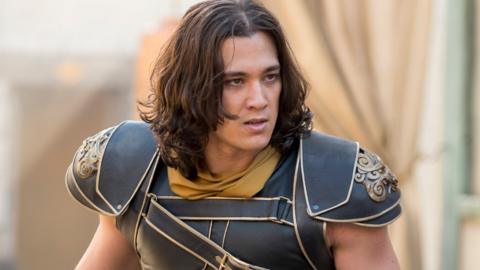 A man with long dark hair and wearing armour looks confused, Monkey.