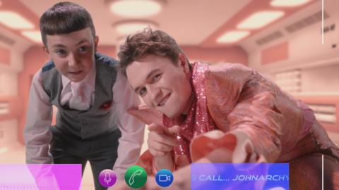 Johnarchy and his manager Malcolm pose for a video call, they look smug.