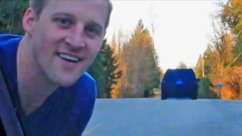 A man smiling and looking through a card window.