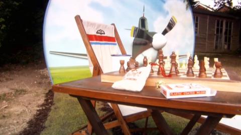 A chess table in front of a model plane.