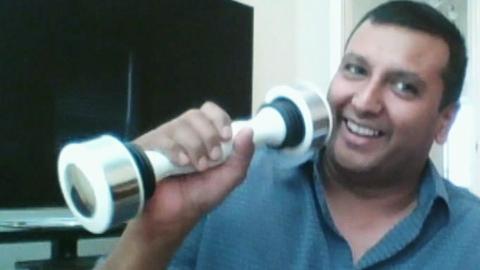 A man singing into a weight.