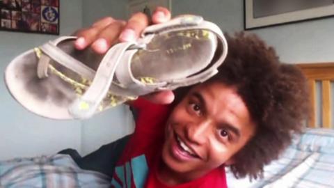 Radzi (Blue Peter presenter) holding a shoe.