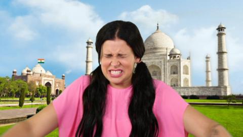 A girl sat in front of the Taj Mahal looking like she's in pain.