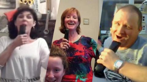 Three parents holding fake microphones pretending to sing.