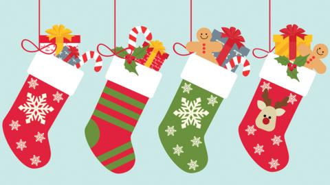 Four Christmas stockings all hanging up filled with toys.