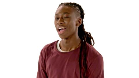 A male dancer with long dark dreadlock hear is winking at camera, Henry from The Next Step.
