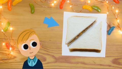 A boy looking at a picture of a sandwich