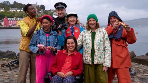 Image of the cast of Balamory posing next to the harbour.