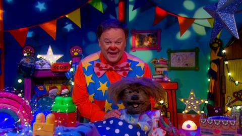 Image of Mr Tumble and Dodge in the CBeebies House bedroom as Mr Tumble sings a lullaby.