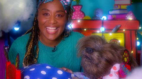 Image of Joanna smiling at the camera whilst Dodge sleeps