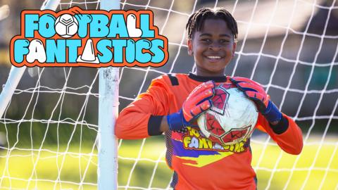 A young ball is a football goalkeeper, he is wearing his kit and holding the football in his hands.