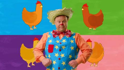 Mr Tumble is next to illustrations of chickens with different colours behind him.