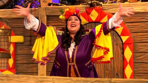 Captain Captain has her arms outstretched in the air whilst smiling.