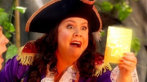 Captain Captain is staring in amazement at a golden sticker.