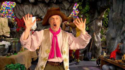 Sandy is shocked and holding his hands in the air.