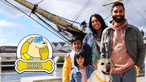 Kika the dog helps a family visit a museum, they are posing in front of a large, old style boat.