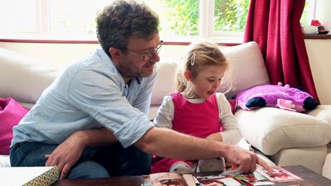 A grown up showing pictures to a little girl.