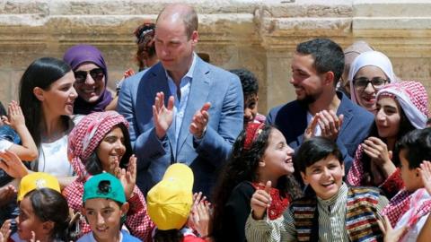 Prince William and Jordan's Crown Prince Hussein interact with children at the ancient city of Jerash