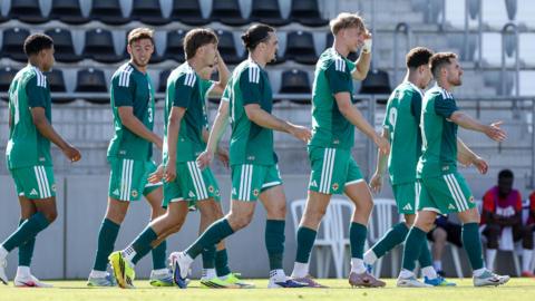 Northern Ireland players walk back to the halfway line while celebrating