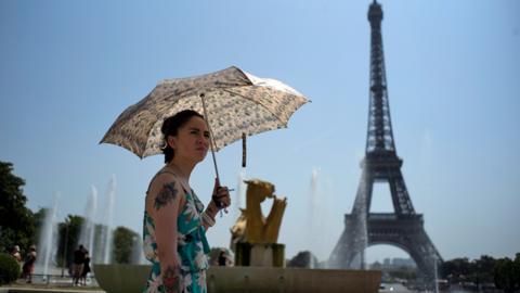 A woman cools down at the fountains of Trocadero, across from the Eiffel Tower, during a heatwave in Paris, France, 25 July 2019. According to forecast, France will experience high temperatures across the country.
