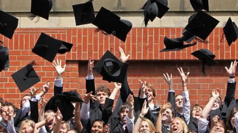students throw their mortarboards in the air