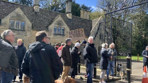 People standing outside iron gates at Cirencester Park