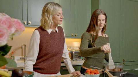 Zoe Ball and daughter Nell melt dark chocolate on an electric stove.
