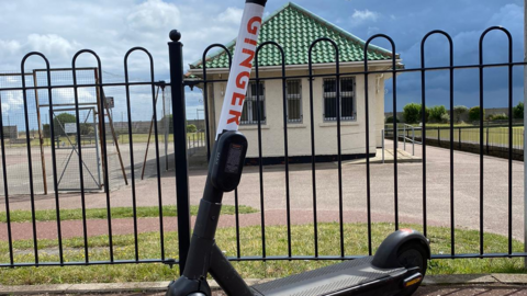 Ginger scooter parked near bowling pavilion in Great Yarmouth