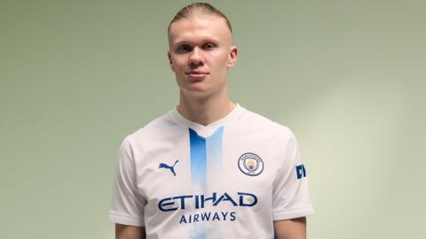 Erling Haaland wearing Manchester City's white and blue third kit