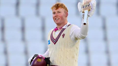 James Rew lifts his bat in celebration