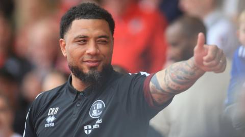 Colin Kazim-Richards holds a thumbs-up and winks at a supporter