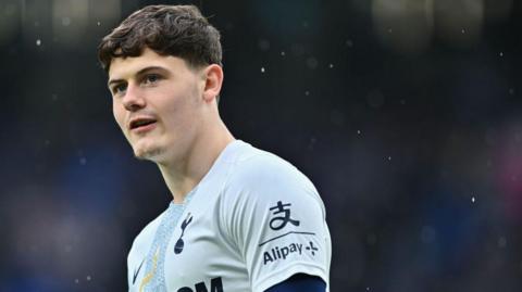 Will Lankshear, wearing Tottenham Hotspur's training shirt, warming up for a match in the rain