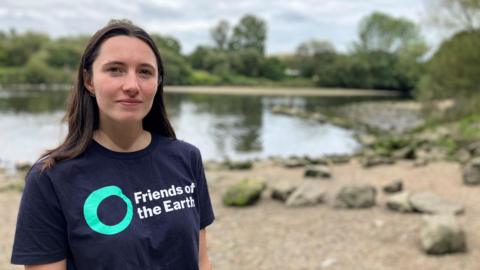 Sienna Somers stands in front of the River Dart in Totnes 