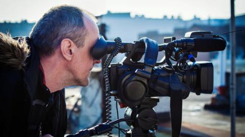 Cameraman filming on location