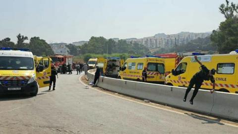Emergency services near the scene of a coach crash in the Boumerdes region of Algeria. A variety of ambulances can be seen with emergency workers outside them. 